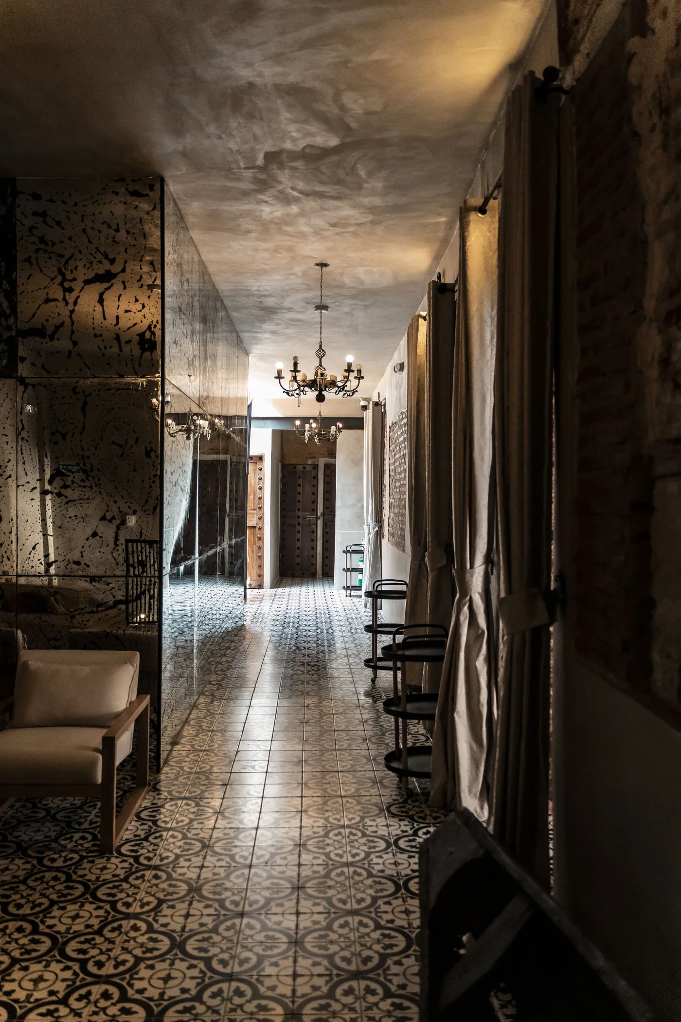 Corredor colonial de Villa Alta con arcos, lámparas colgantes y piso de baldosa hidráulica.